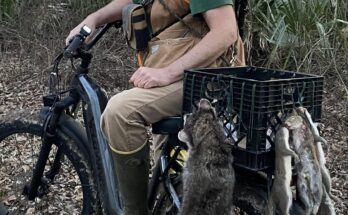 Hunter sitting on ebike with squirrels hanging from crate